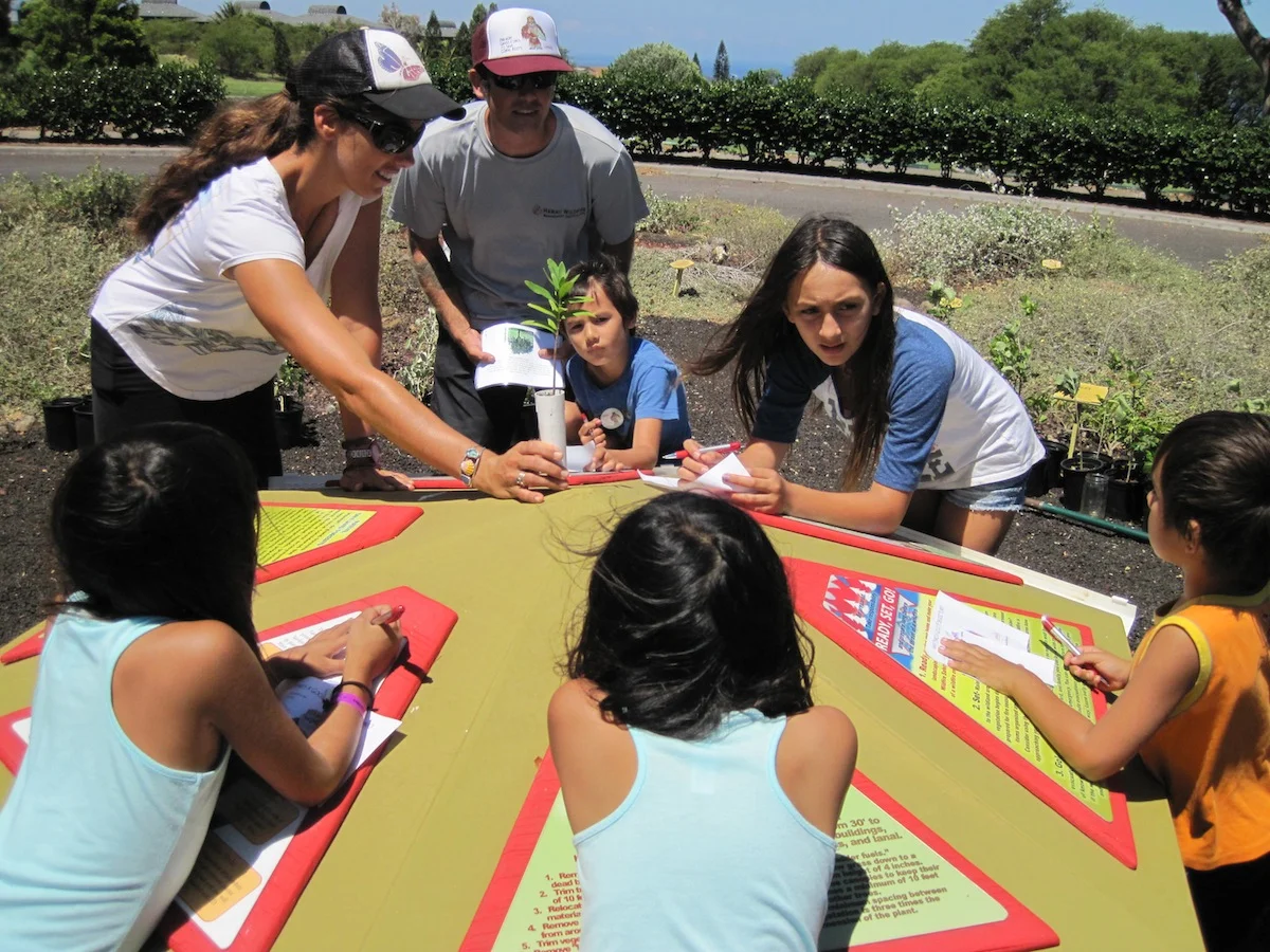 Waikoloa Dry Forest Initiative's Jess holds a sandalwood (ʻiliahi) during the Firewise Plant Game Show.