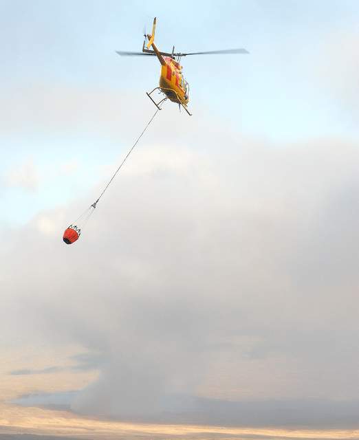 "A Hawaii County Fire Helicopter makes a water drop on a brush fire in Parker Ranch on Friday afternoon. Laura Shimabuku/West Hawaii Today"