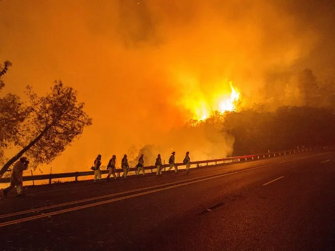 CalFire firefighters walk along Highway 20 as the Rocky Fire burns near Clearlake, Calif. The fire has charred more than 27,000 acres and is currently only 5% contained. Josh Edelson, AFP/Getty Images