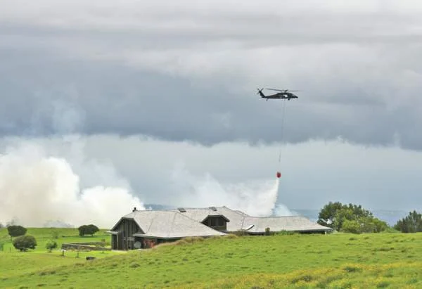 "An Army UH-60 Blackhawk drops water on a fire near Waikii Ranch on Monday afternoon. The crew came from the medevac team." (Graham Milldrum / West Hawaii Today)