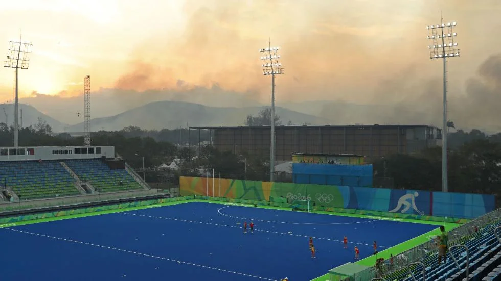 "Athletes from Spain warm up on the pitch as a wildfire burns in the nearby hills of Deodoro before the quarterfinal hockey game against Great Britain on Day 10 of the Rio 2016 Olympic Games, Aug. 15, 2016 in Rio de Janeiro, Brazil." (Christian Petersen/Getty Images)