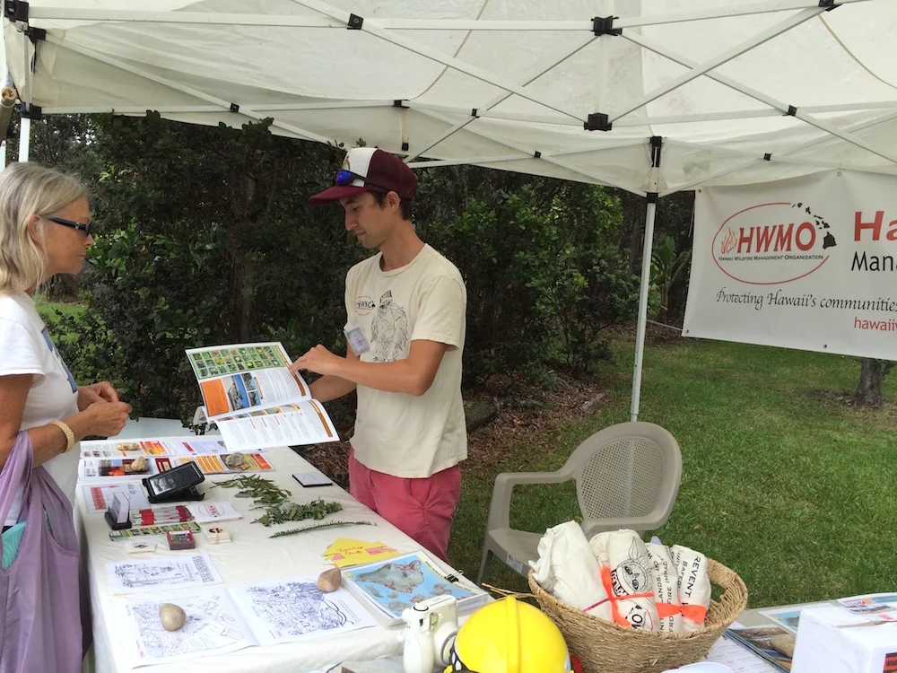 Pablo Beimler presents a copy of the Ready, Set, Go! Wildland Action Guide to a visiting resident.
