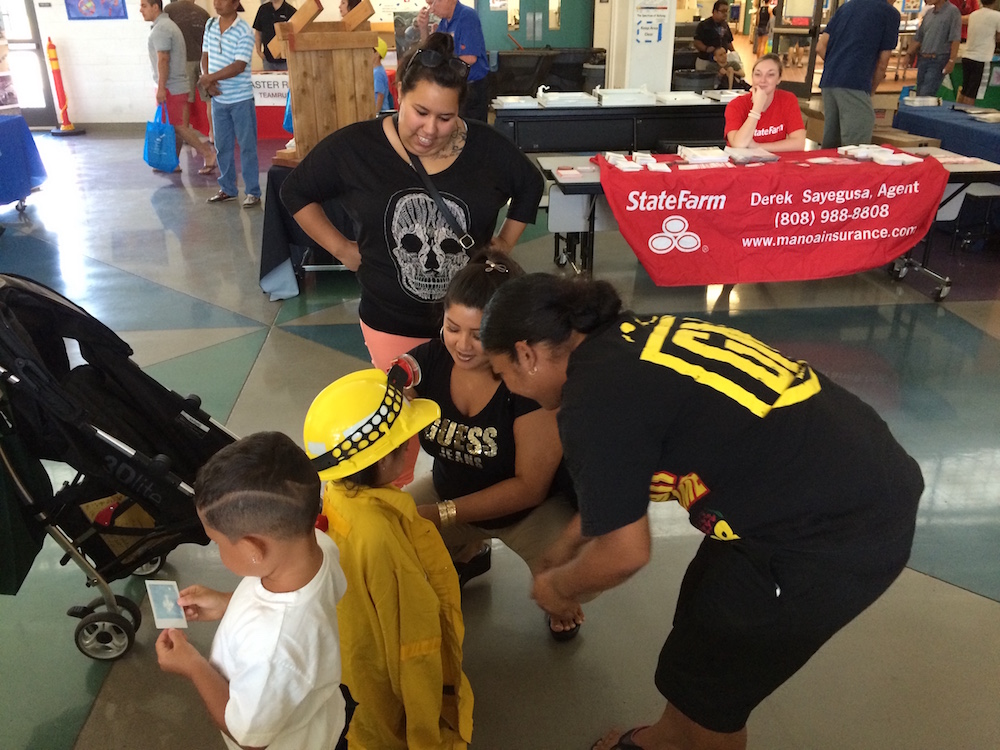 A family stops by for Ready Set Go! information and wildland firefighter photo shoot.