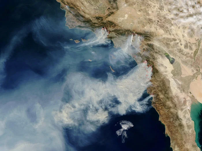 "More than 10 wildfires burned over 200,000 acres in Southern California in October 2003, many of them started by humans. This satellite image shows strong winds carrying smoke over the Pacific." Credit: MODIS Rapid Response Team/NASA
