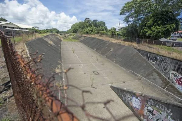 "The flood channel that runs under the intersection of Kinoole and Mohouli streets in Hilo was dry Tuesday." Credit - Hollyn Johnson / Hawaii Tribune-Herald