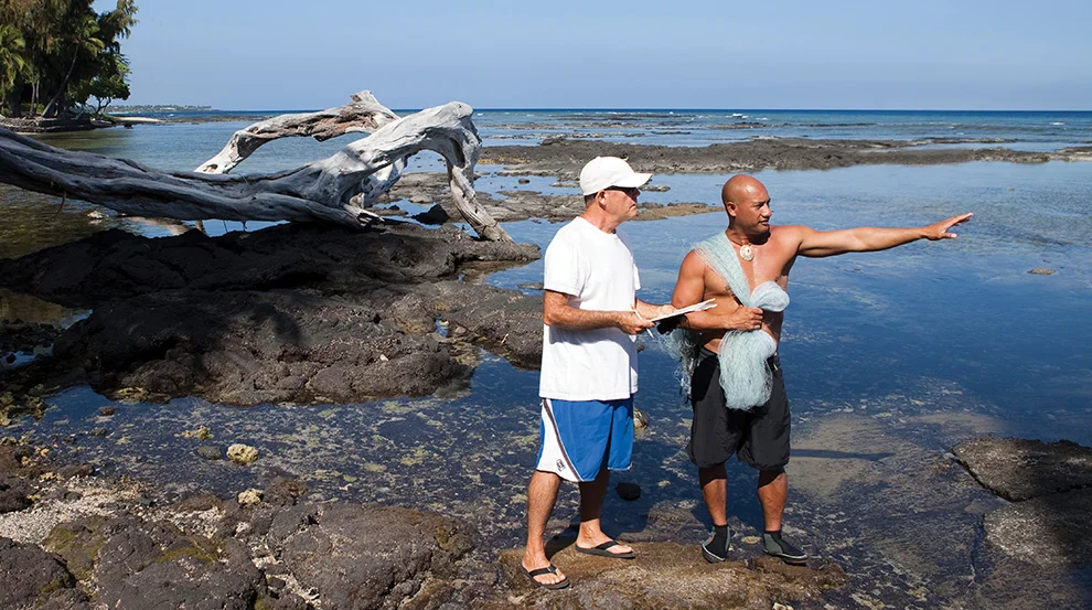 "Dedicated Makai Watch Volunteer James Heacock (clipboard) has been doing surveys for 10 years. Here, he surveys the coast with fisherman Kawika Auld." Photo courtesy of Christine Shepard