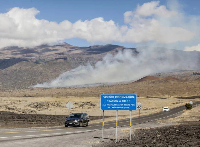 “A brush fire continues to burn off Daniel K. Inouye Highway Wednesday near near the Maunakea Access Road.” (HOLLYN JOHNSON/Tribune-Herald)