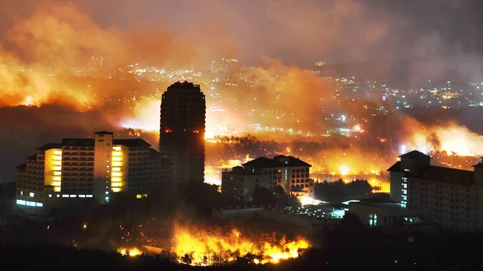“A forest fire is seen raging near buildings in Sokcho, South Korea. South Korea mobilized troops and helicopters to deal with the massive blaze that roared through forests and cities along the eastern coast.” Credit: Kangwon Ilbo / Getty Images