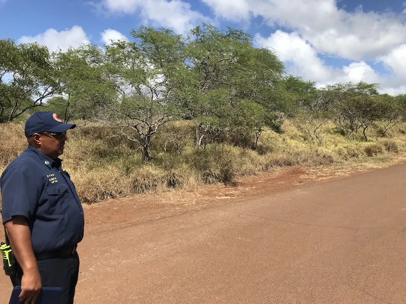 Captain Hanale Lindo of Maui Fire Department in front of roadside fuels.