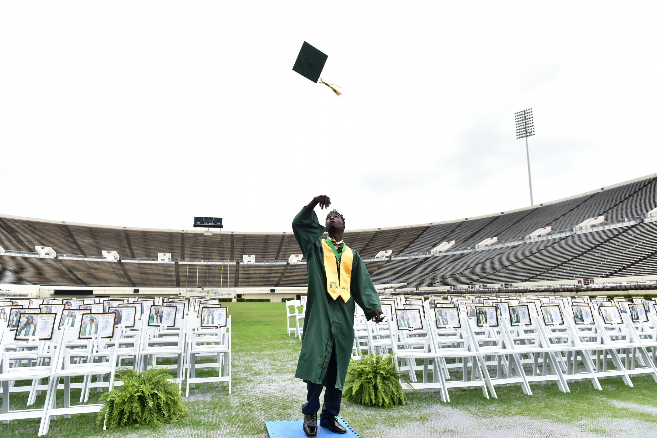 Jim Hill high School senior Jonah Johnson tosses his graduation cap after taking a class picture with portraits of his classmates as a stand in for the group on Thursday morning at Mississippi Veterans Memorial Stadium in Jackson. Because of social