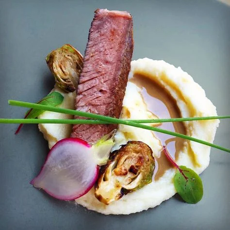Entree: Pan Seared Seasonal Fillet of Fish served over Chickpea Puree and Accompanied by a Mediterranean Artichoke, Tomato and Olive Ragout