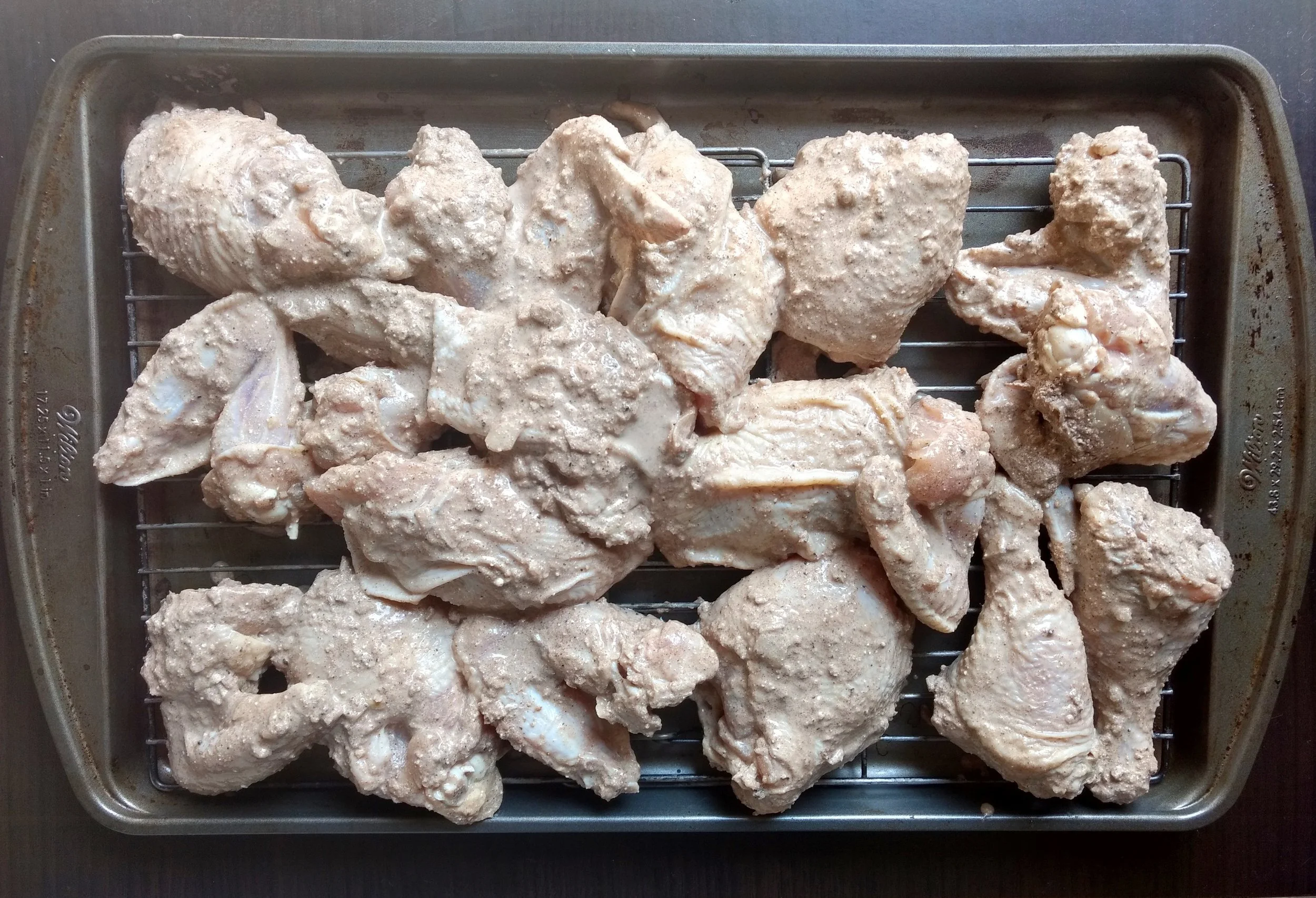 3. Pre-heat the oven to 350 degrees while you are putting the marinated chicken on a baking tray with racks for even cooking. Bake for 90 minutes or until brown, crisp and cooked through.