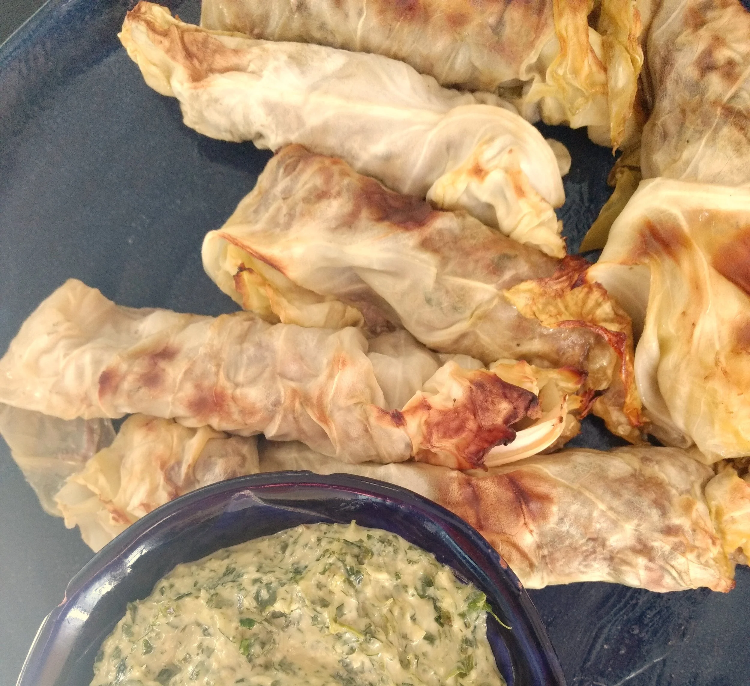 Cabbage rolls have always intimidated me a bit because of the cabbage. Until I was inspired by a recipe in Saveur magazine with its gorgeous cabbage rolls, I didn't even do the research on how to get the leaves to stay whole. Its actually surprisingly easy! Having a pari of tongs in your kitchen is what makes it all work. Because we do so much grilling, I have tongs on hand. A whole cabbage has enough leaves for two meals, so I freeze the left overs and use them the next time I am ready for cabbage rolls. When making this recipe I also double up on the lamb stuffing and freeze it so that I have the makings for another round for a busy day when I don't have time to go through the entire process. The green tahini sauce is vibrant with parsley and an amazing side! I'll include the recipe soon...