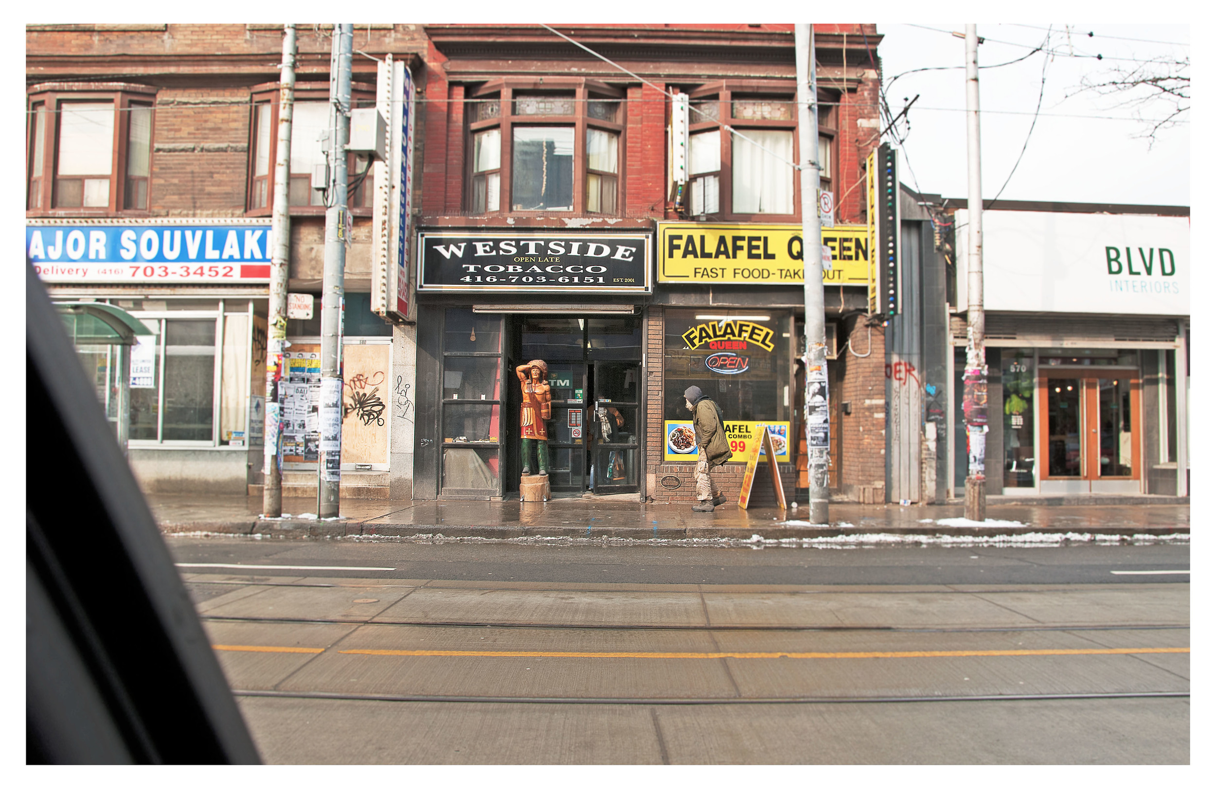 30. Toronto, Ontario,  drive-by view of Cigar store Indian and street person, Queen St and Bathurst .jpg
