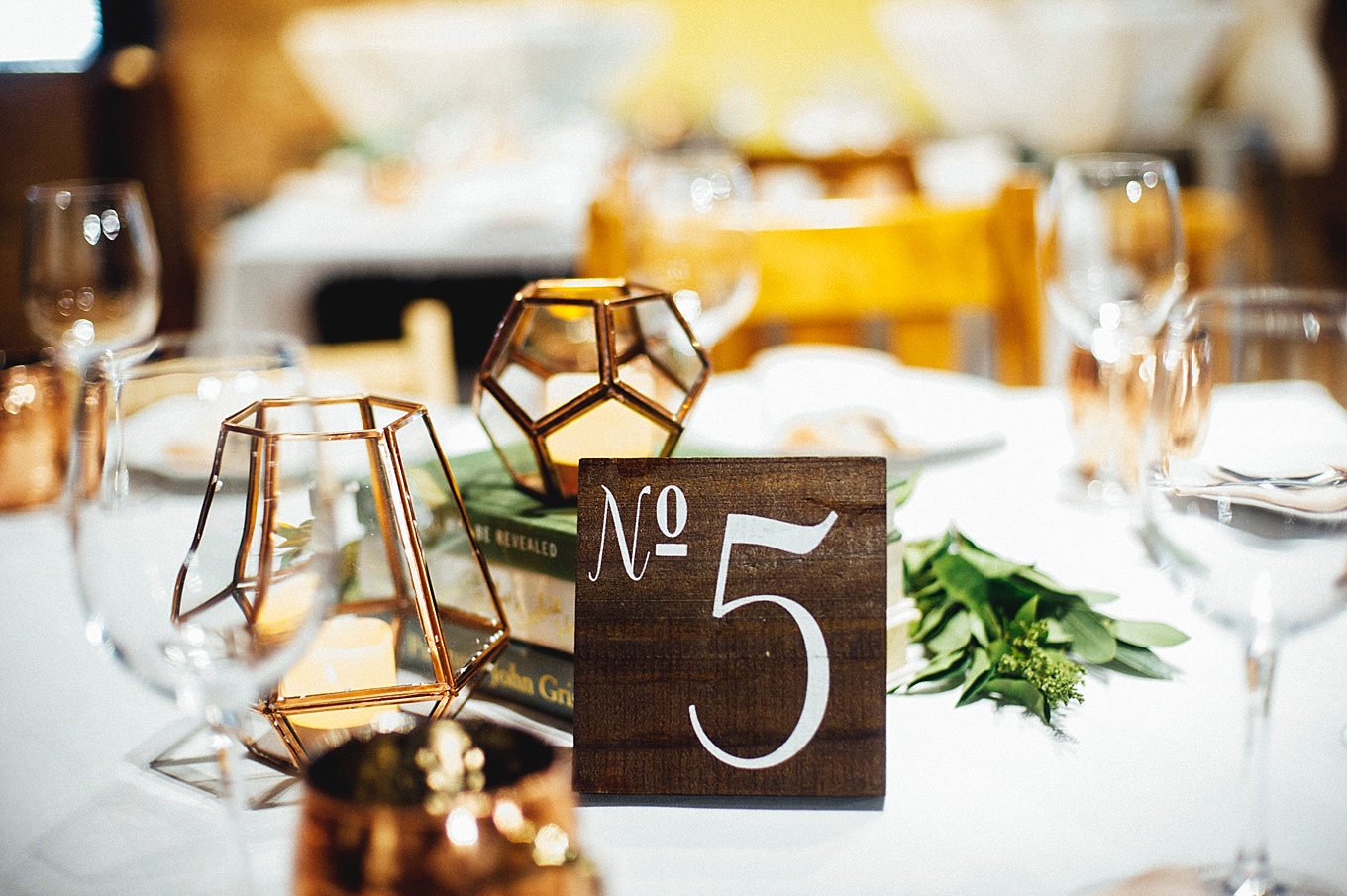A centerpiece of books and candles is enhanced with a minimal pop of greenery (photo by Christian Wilson )