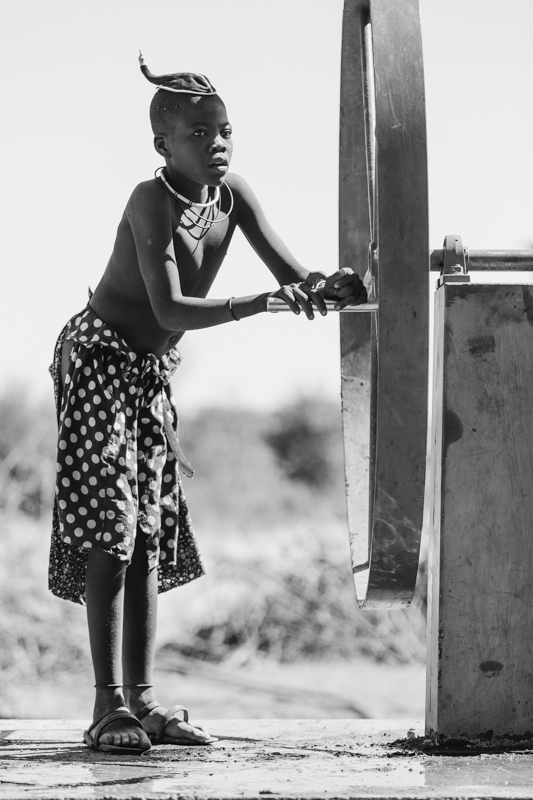 A young Himba boy pumps water from a well, which he will then carry home in drums to his village. Onconcua, Cunene Province ©24Atlantic