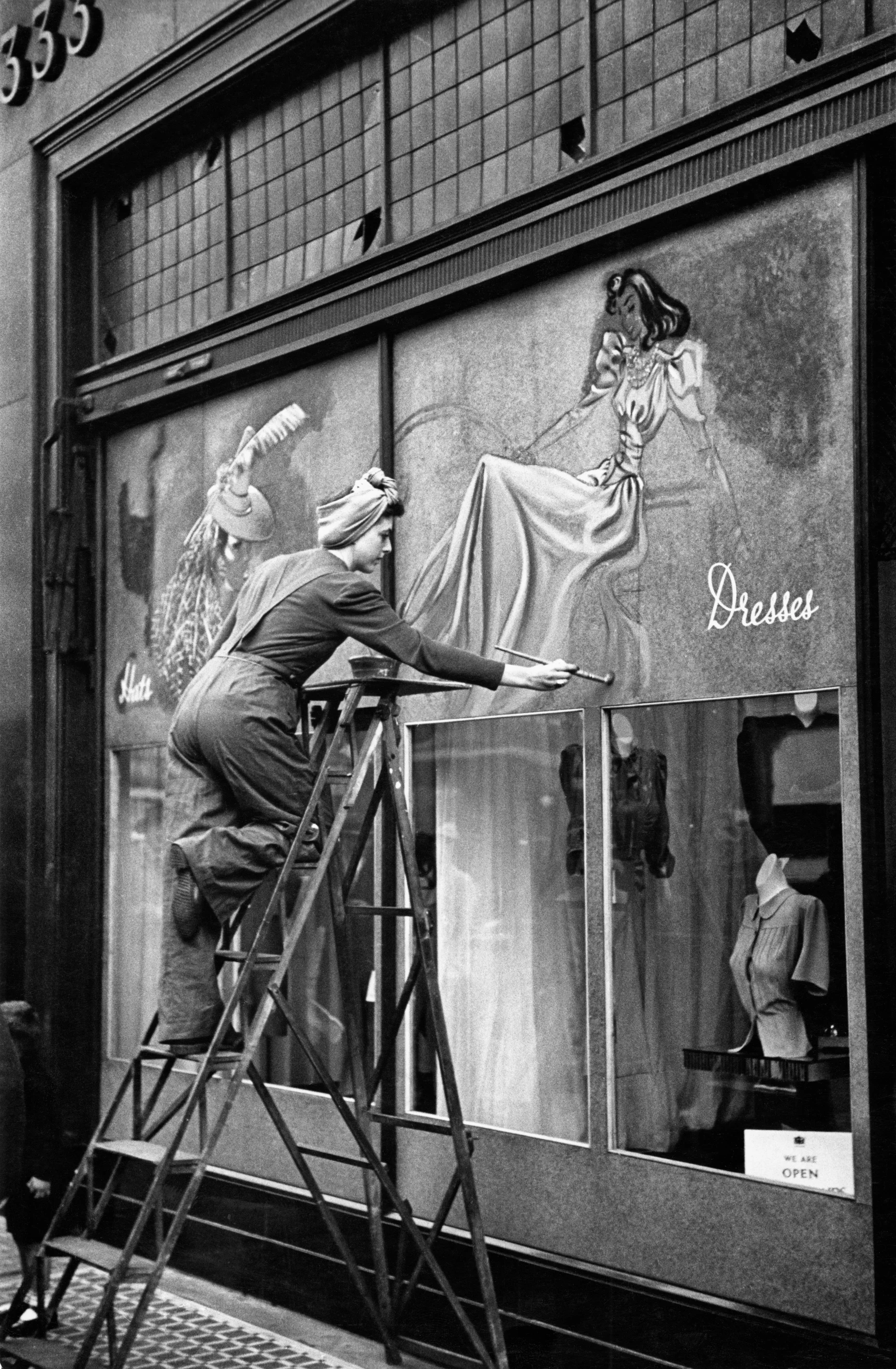 Decorating the hoardings on the shattered shopfronts of Oxford Street, London 1940