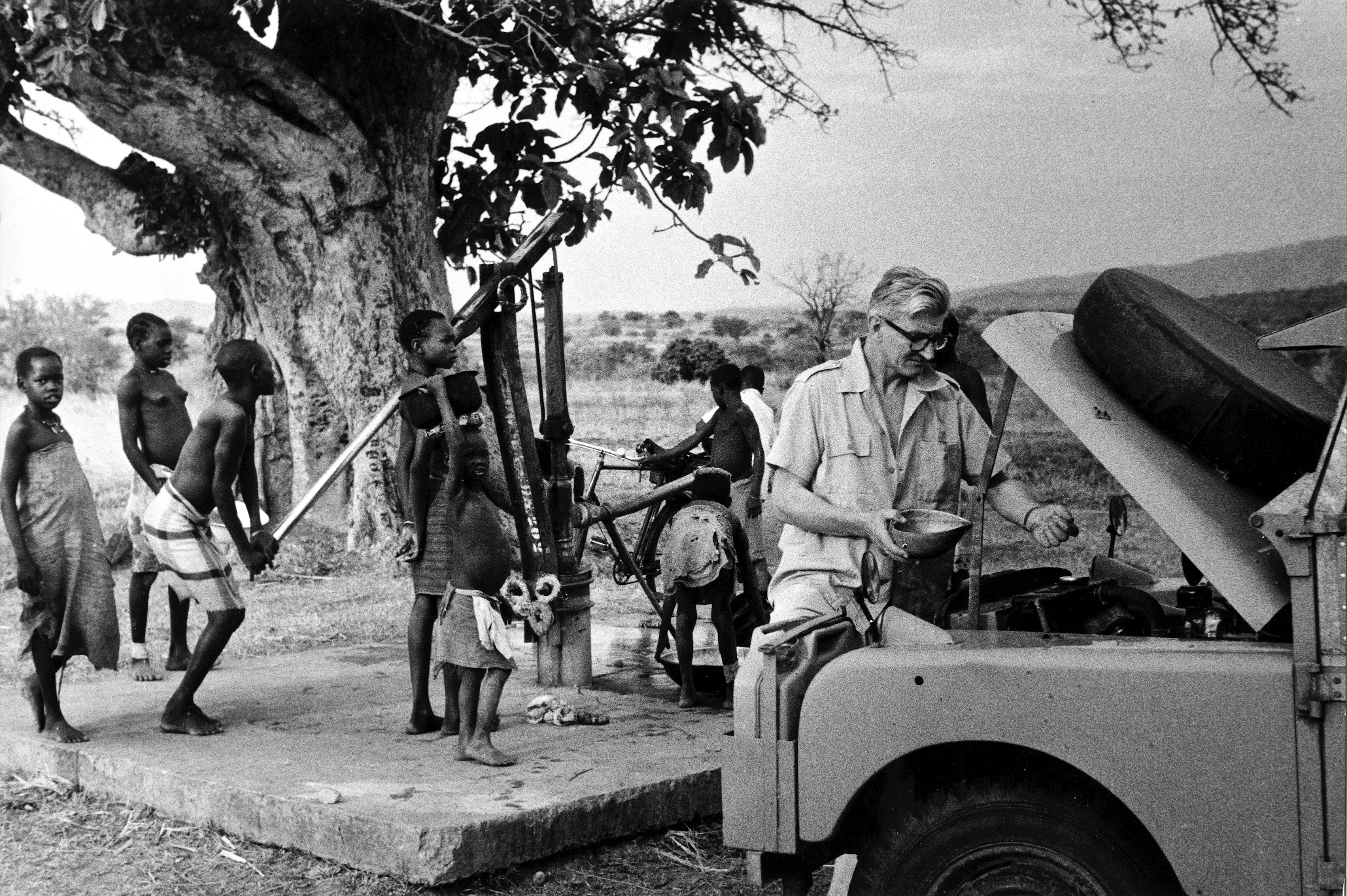 A stop to fill up with water and test the radiator, Northern Uganda 1958