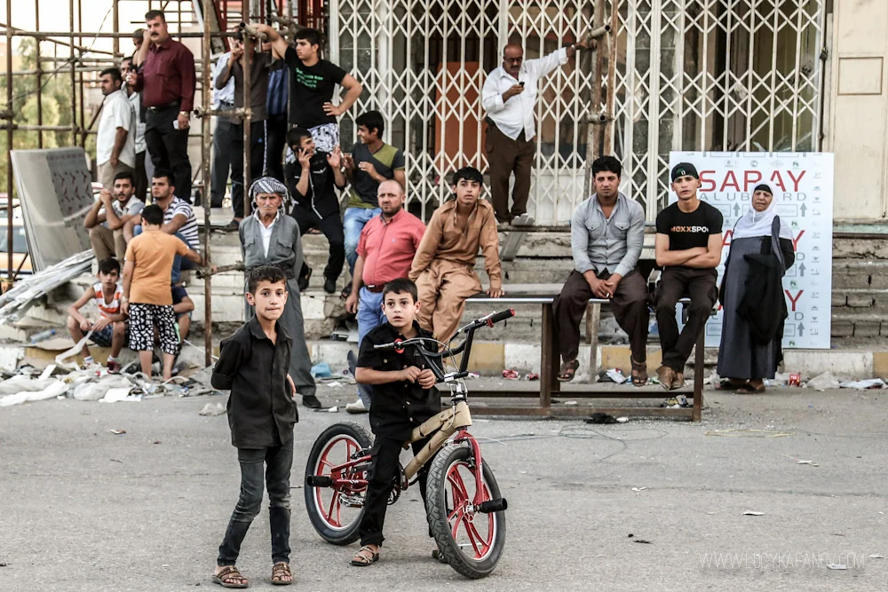 Neighborhood residents look on as people run around in the chaotic aftermath of the suicide blast. Photograph by Lucy Kafanov.