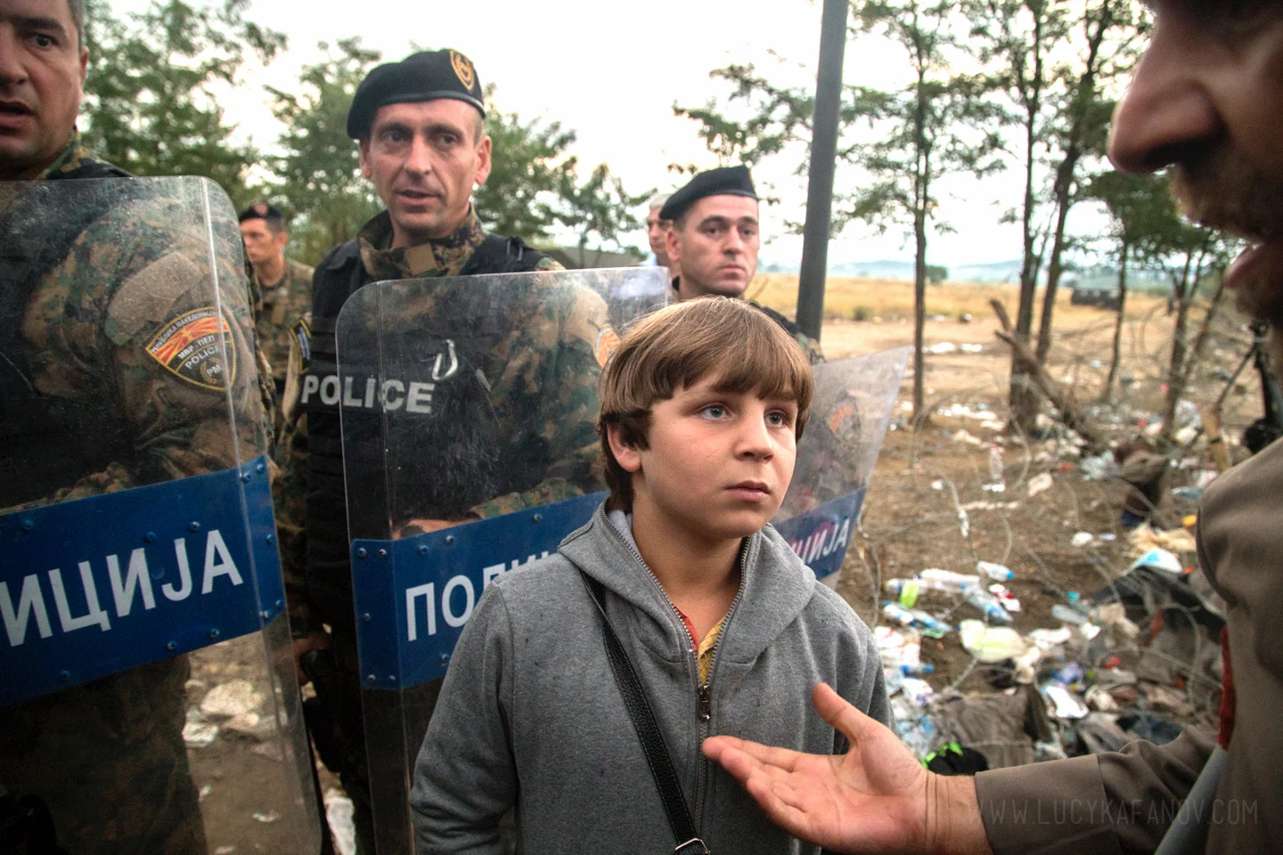 Surrounded by Macedonian riot police, a Syrian boy waits to cross into the country from Greece.