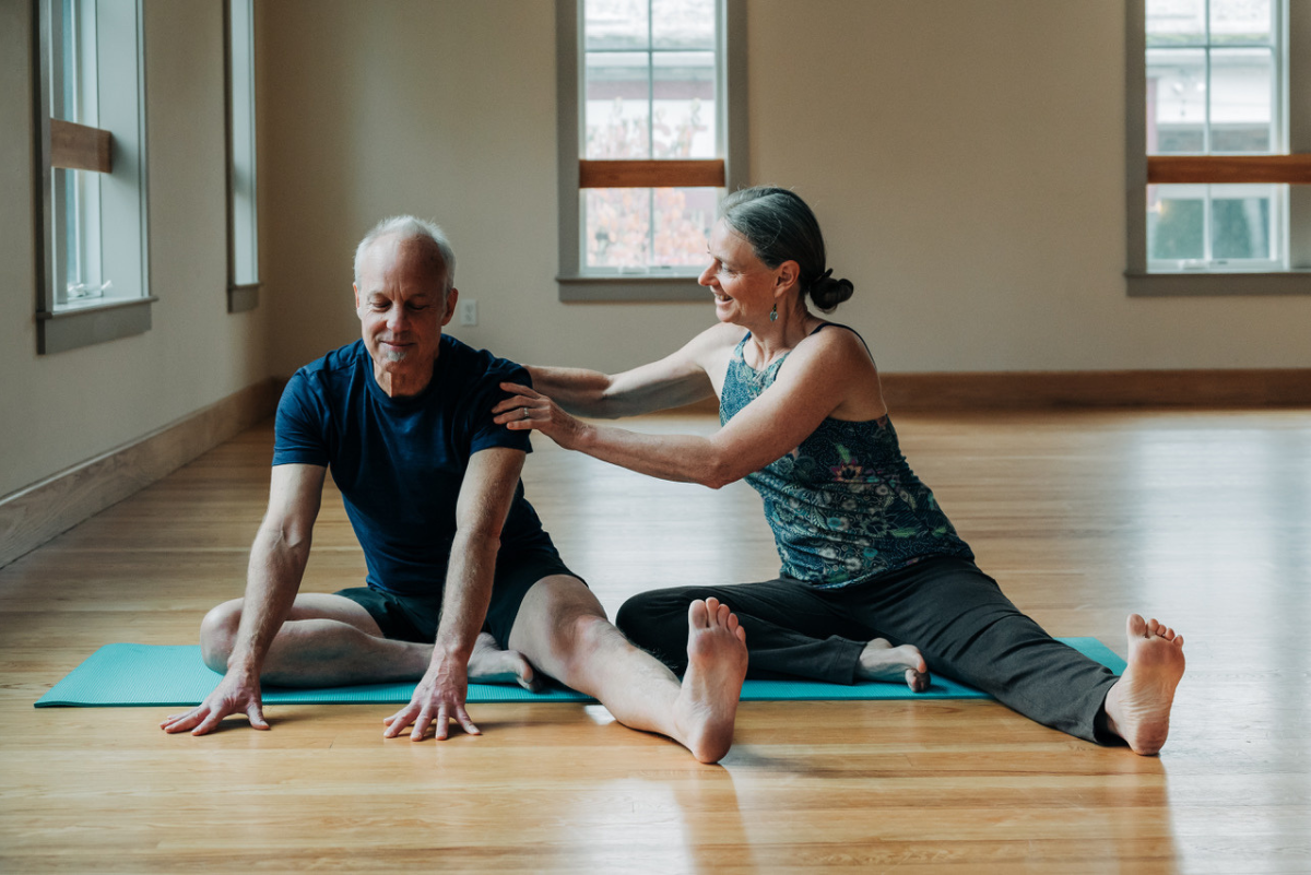 Katie helping yogi through their yoga practice