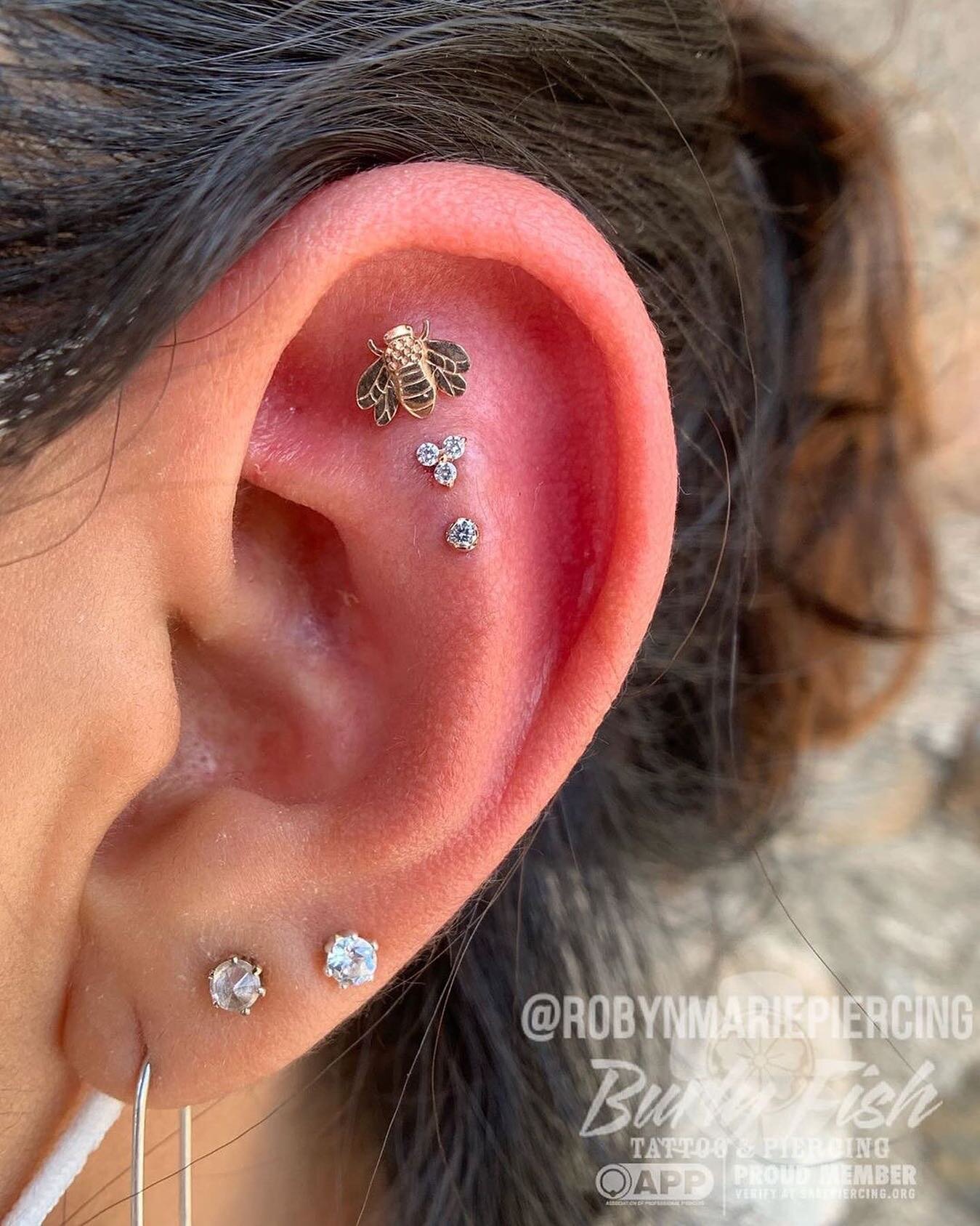 @robynmariepiercing says &lsquo;Triple helix...so hot right now!&rsquo; This lady was inspired by a triple helix Robyn posted recently, so we curated this yellow gold setup just for her. She chose a bee from @kiwidiamondjewelry, a trinity from @leroi