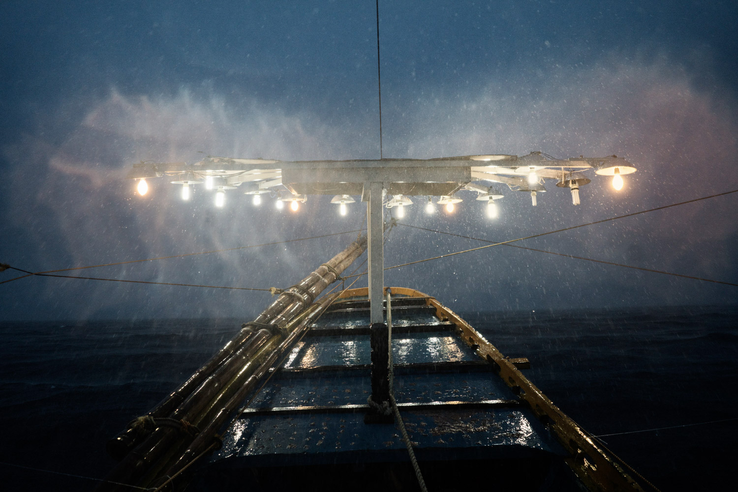 The lights used to attract fish towards the boat are seen during a storm on 'Melissa' - a 15.53 gross ton basnig fishing boat - while they head out to fishing grounds in national waters close to the South China Sea, from Quezon, Palawan, The Philippines on June 27th, 2016.