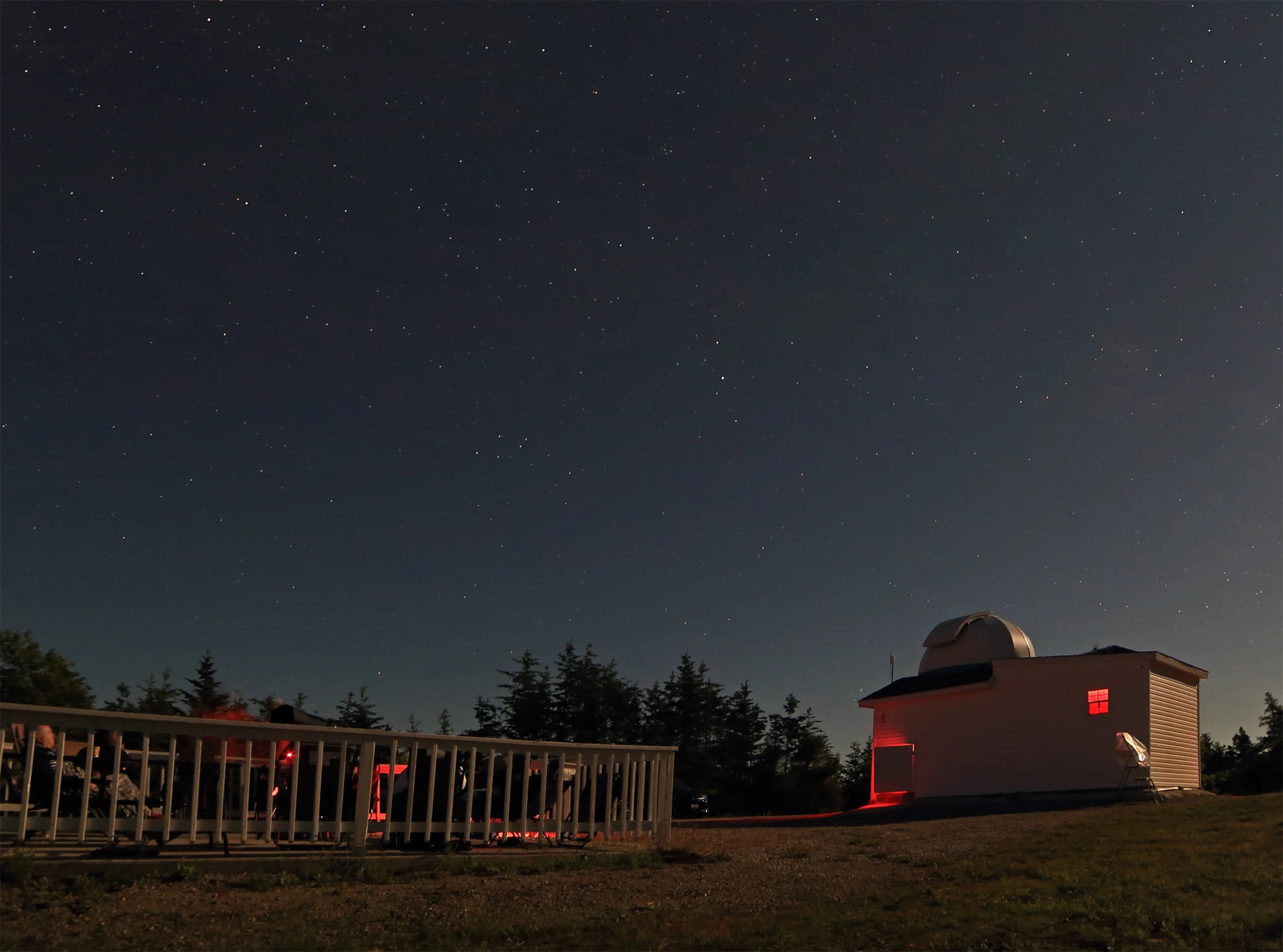 Half the group waits for their turn in the dome while the others peer through the telescope. 