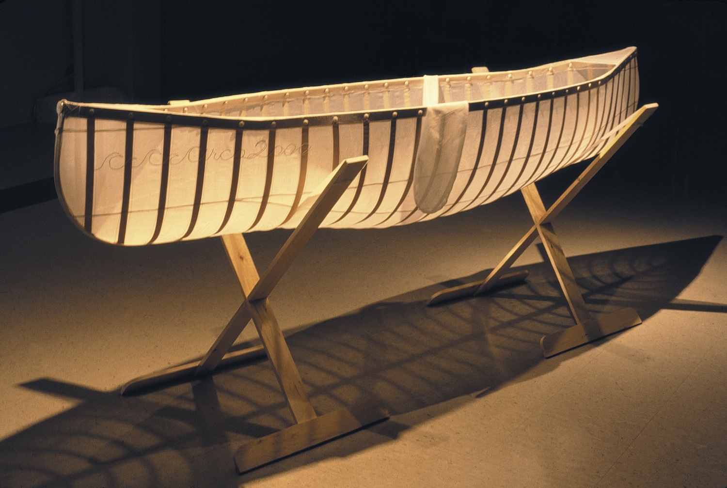   Learning Canoe , 1998 Silk organza, birch veneer ribbing, tailor’s chalk, embroidery, mother of pearl buttons,
steel pins, pine cradle 92.5x240x 60cm      
  
				 
			 
		 