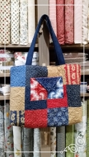 Here's a photo of the Charm Party Tote that we made, hanging in the shop (finished tote is not included in the prize package).