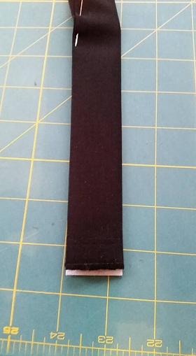 2. After pressing Décor Bond in place, refold edges of handle fabric back to middle enclosing the strip of Décor bond inside the handle fabric. Baste with matching Aurifil thread along open edges of handle .