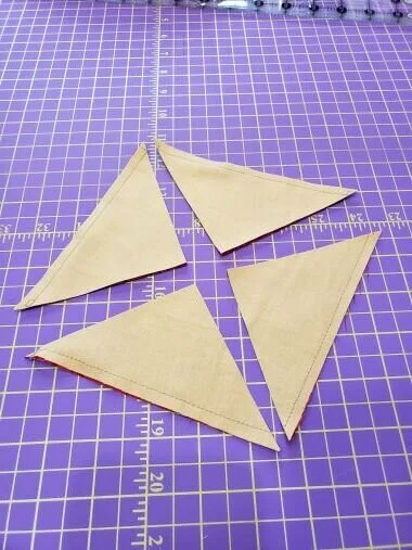 You can mark a diagonal line across both directions on the wrong side of the top fabric square.Then Using your rotary blade, cut the square in quarters following the drawn diagonal lines. I don’t draw the lines . I just place a ruler on the diagonal (corner to corner) and cut the squares apart that way.