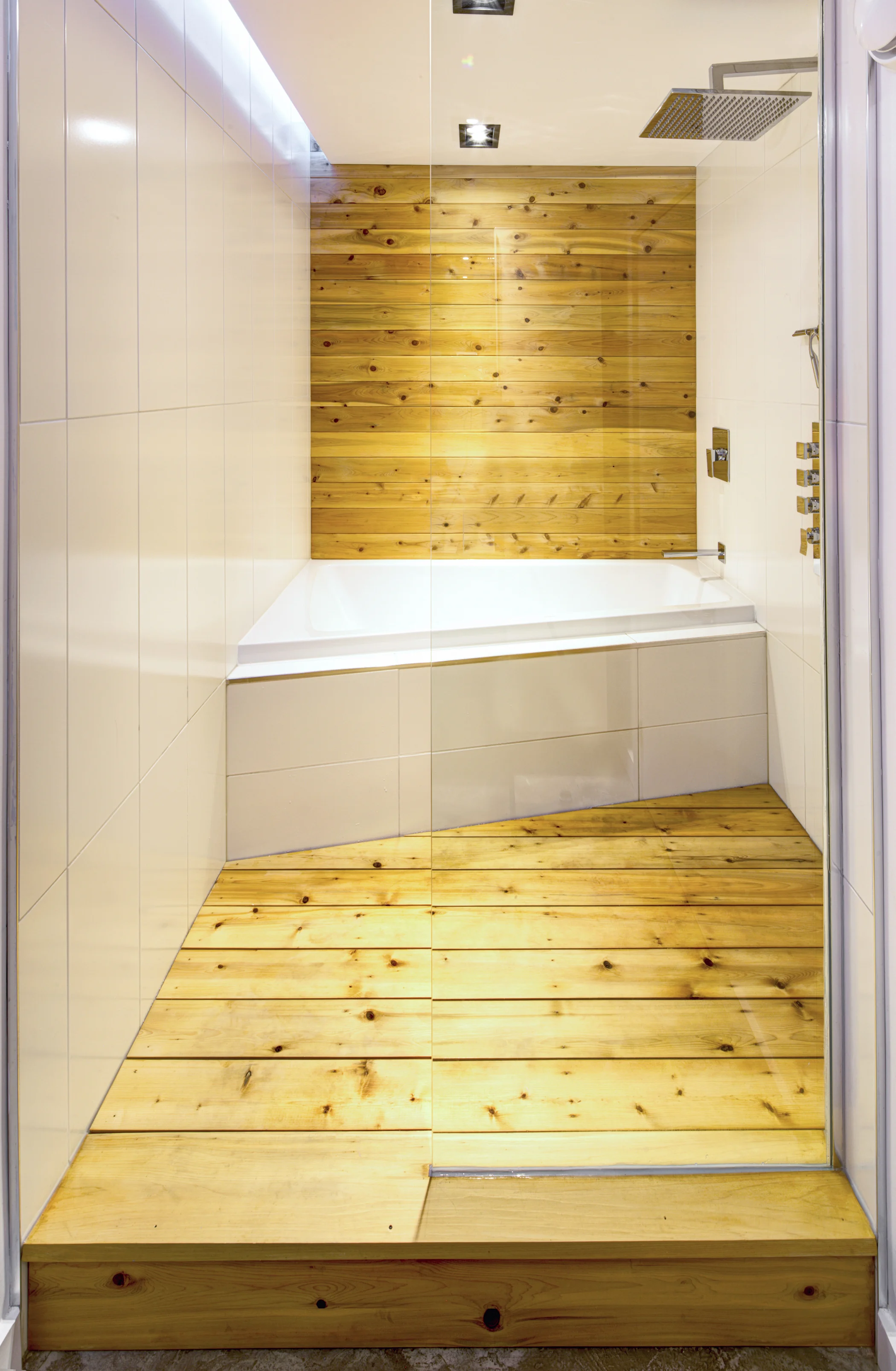 Spa-esque bathroom with soaker tub and rain shower head with thick wood panels on walls and floors of The Borg addition and renovation