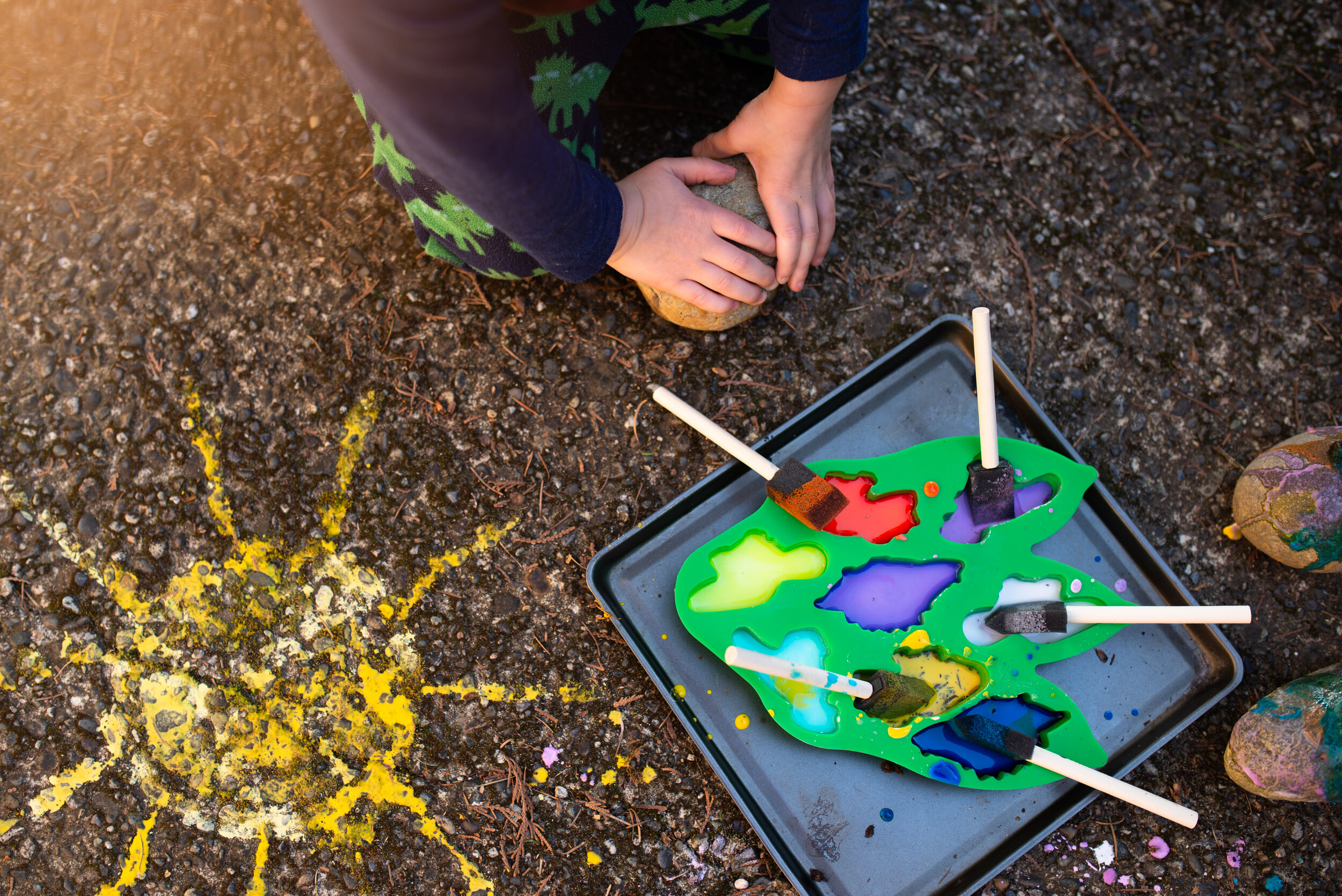 Painting the cement and rocks with our homemade sidewalk chalk paint.