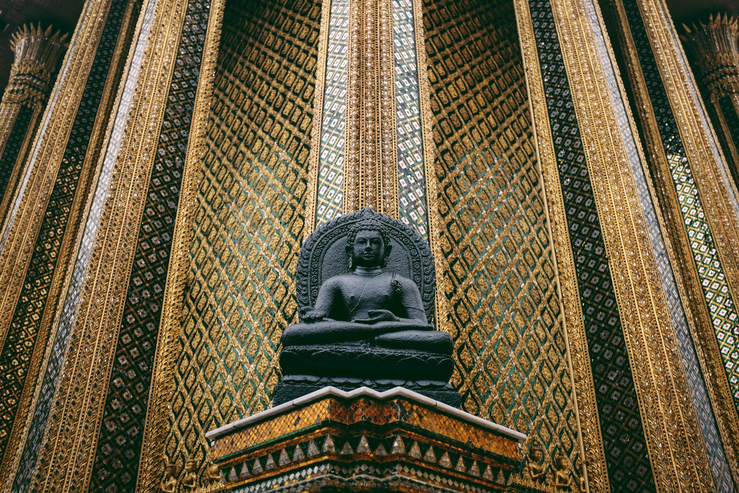 Bronze Buddha statue with soft temple blur — travel image by Vancouver photographer Tom L A Jones