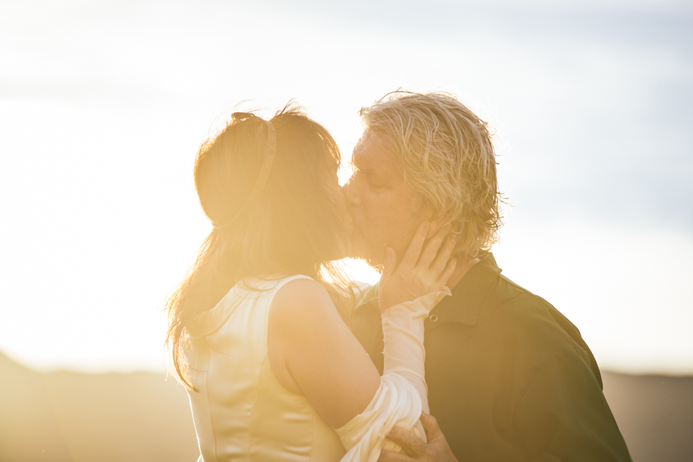 First-kiss wedding moment before a mountain range, Vancouver BC — photo by Tom L A Jones