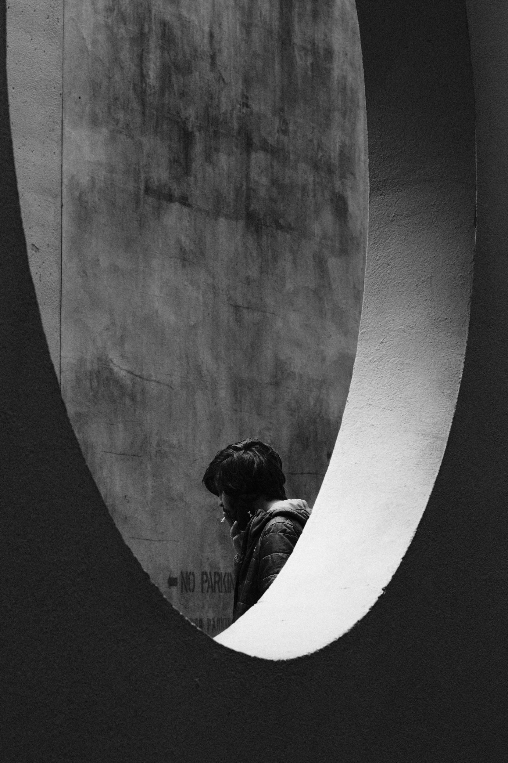 Candid street scene: man smoking beside concrete wall, Vancouver BC — image by Tom L A Jones