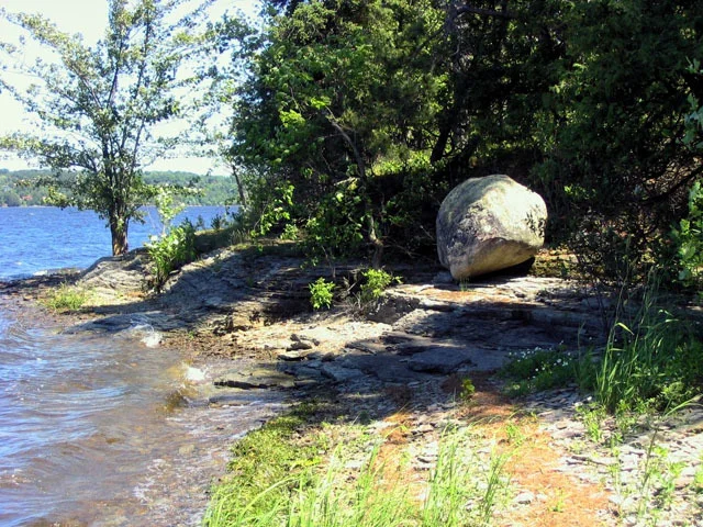 Precambrian erratic boulder on Rockcliffe Formation sandstone, Pinhey's Point. Photo by J. Aylsworth