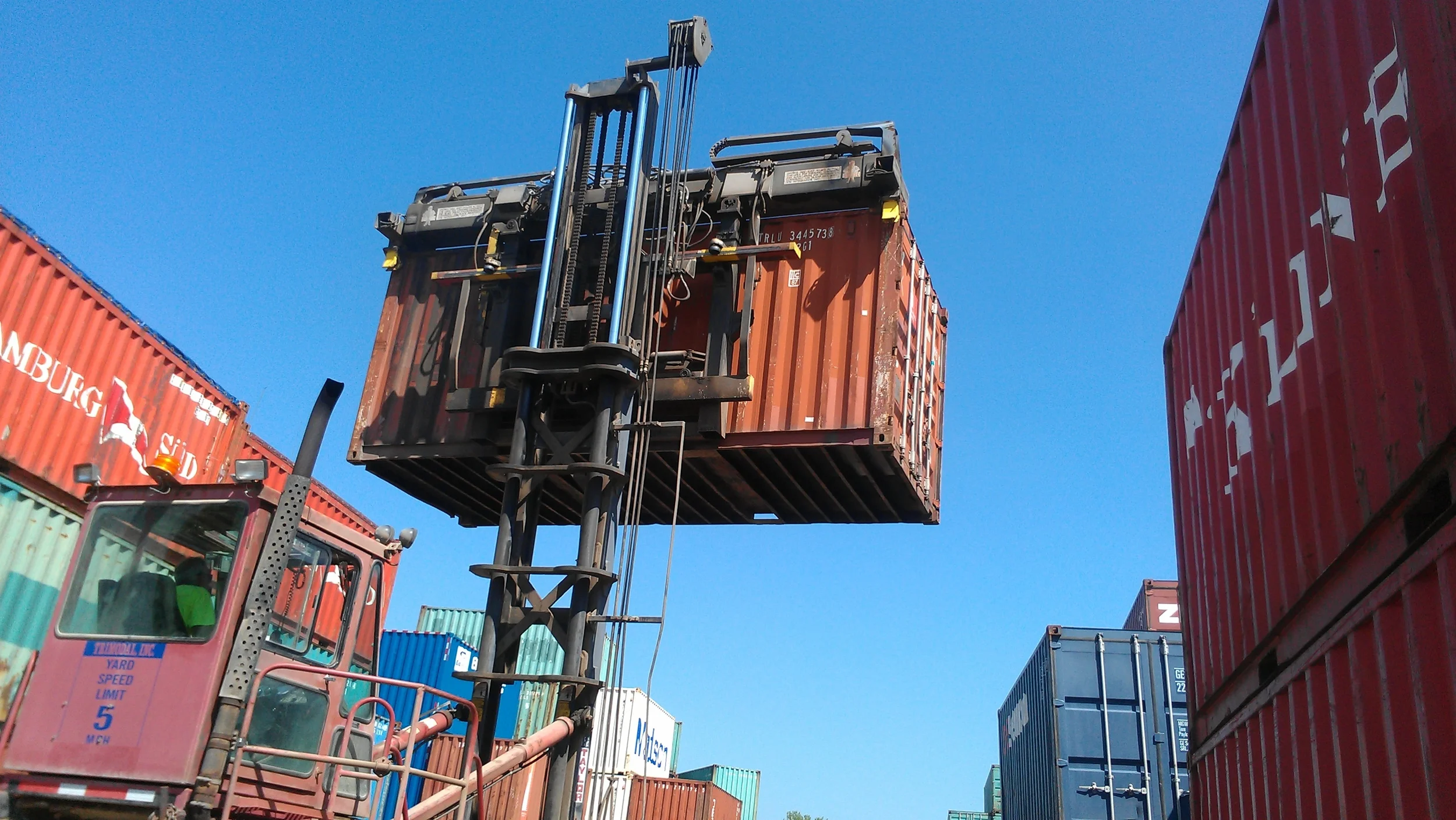 Container forklift picks up the container from the top 2 corners