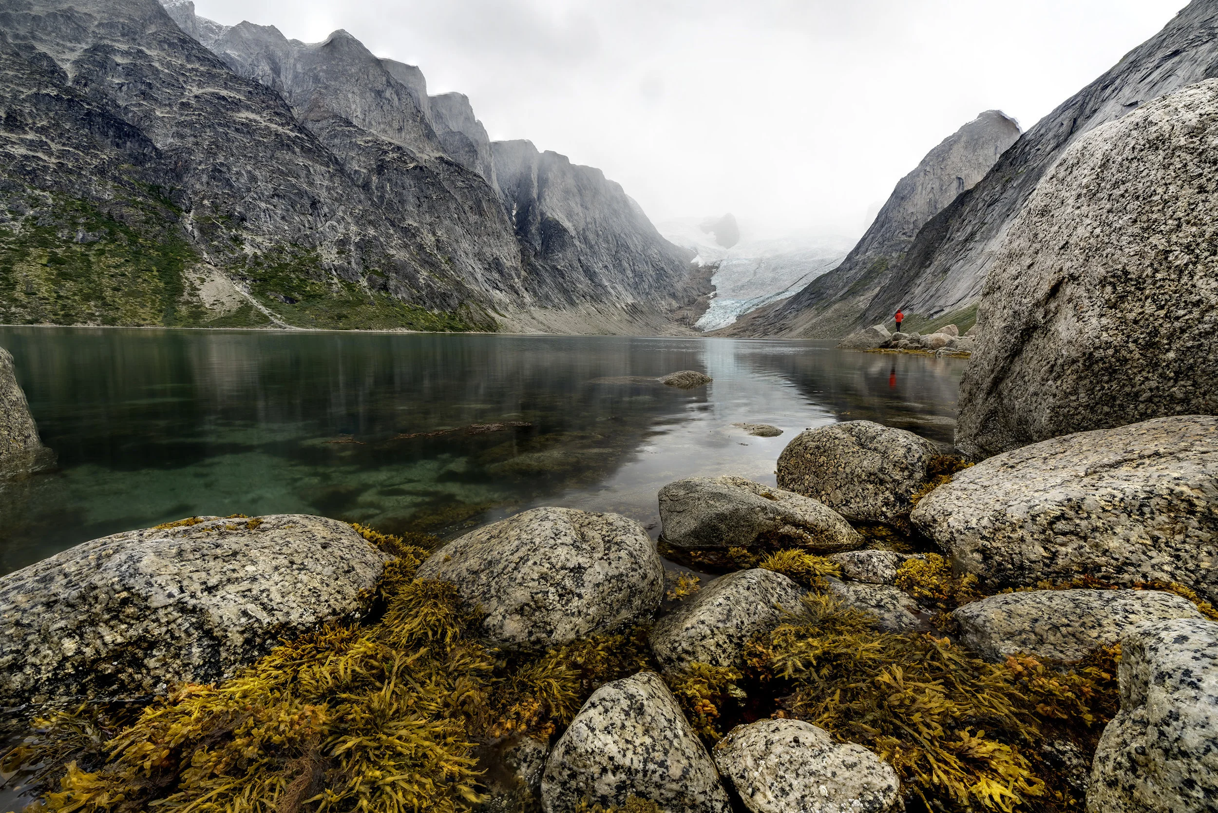 Damon i rød jakke i baggrunden. Man lige se gletcheren i bunden af fjorden