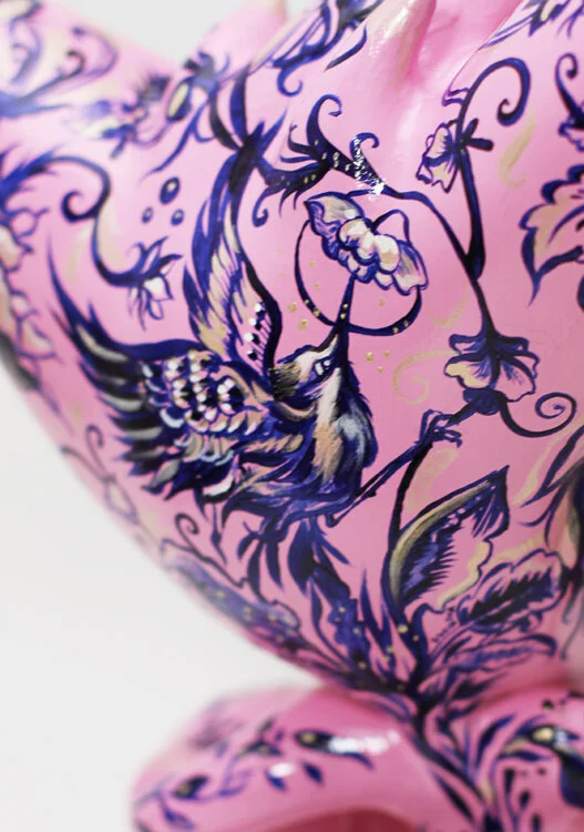Detail of the pink Pjipje sculpture showing a hand-painted bird surrounded by floral ornament in Anna Sokolova's Contemporary Delft Blue-inspired illustration style.