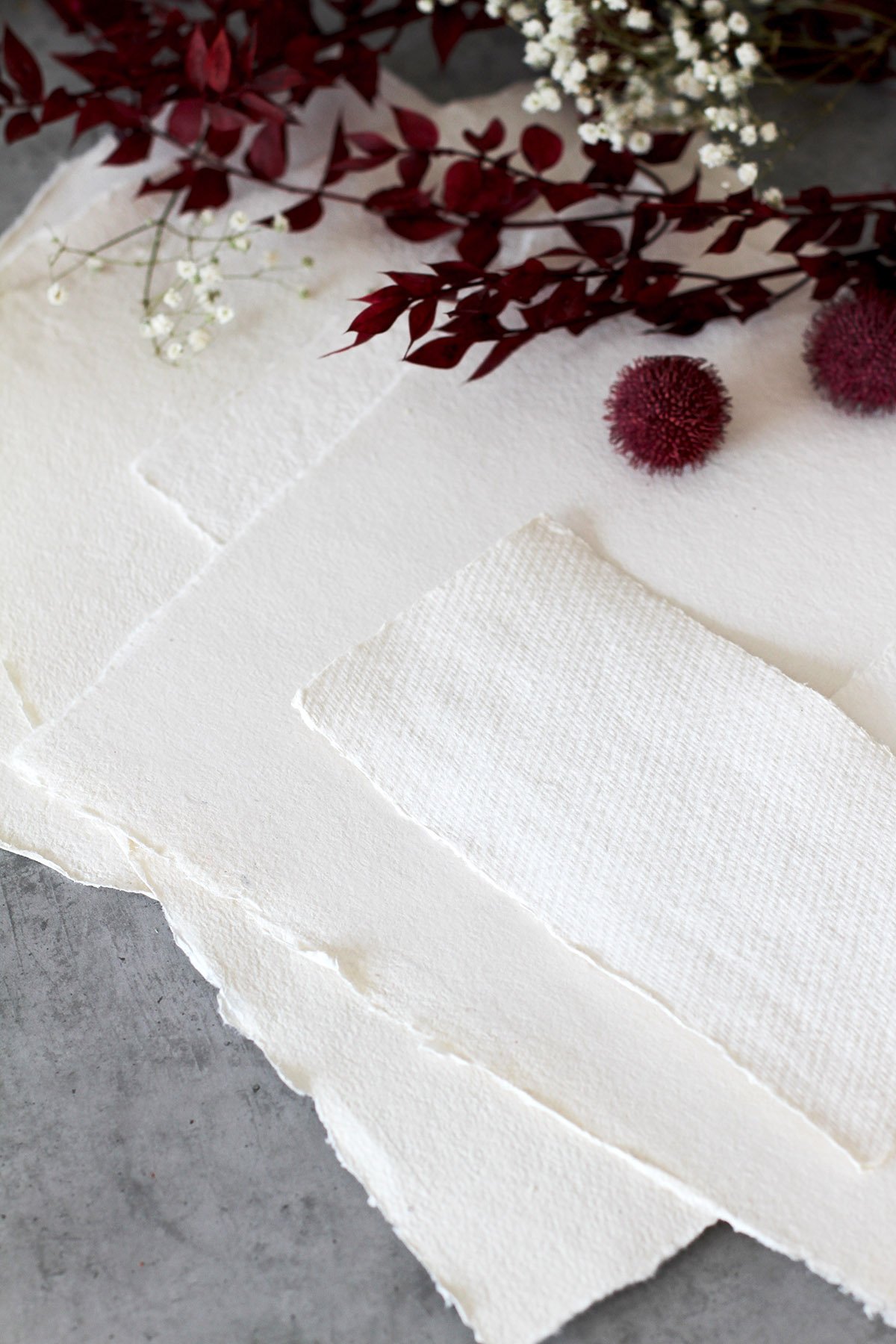 Handmade watercolor paper sheets with red foliage and baby’s breath