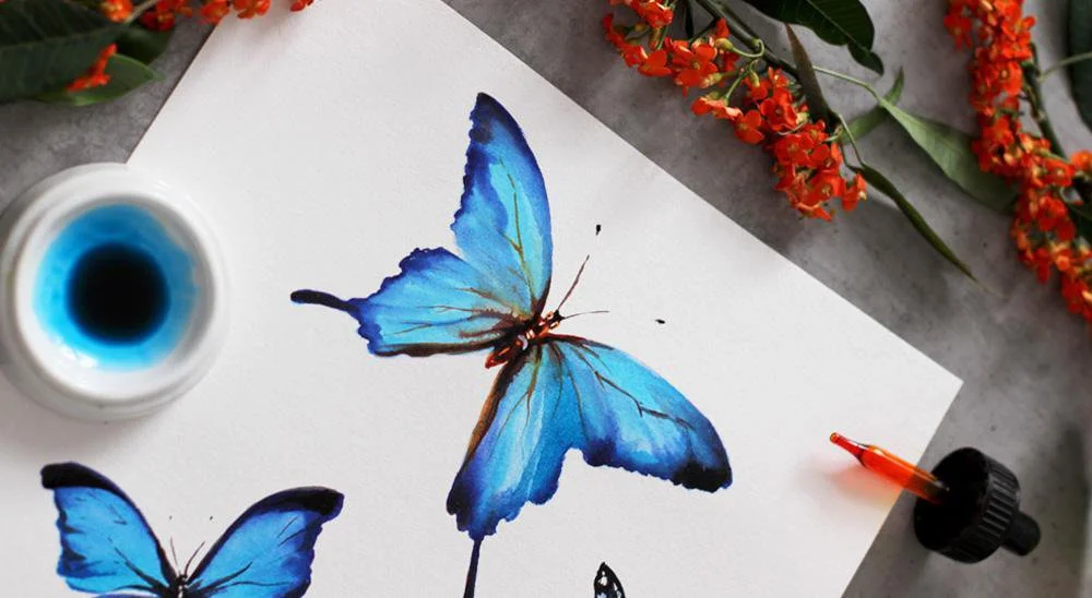 Blue butterflies created with colored inks on toned paper
