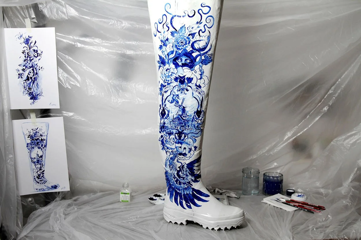 Hand-painted Maison Margiela Artisanal wader in Anna Sokolova's studio alongside concept sketches, illustrating the Contemporary Delft Blue design process.