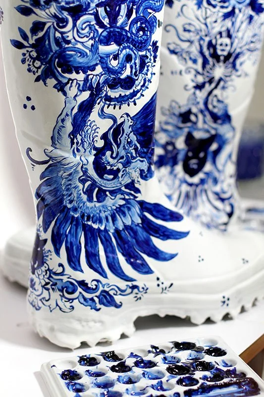 Detail of Maison Margiela Artisanal hand-painted waders by Anna Sokolova featuring Contemporary Delft Blue ornament, mythical bird, and blue-and-white ceramic-inspired illustration.