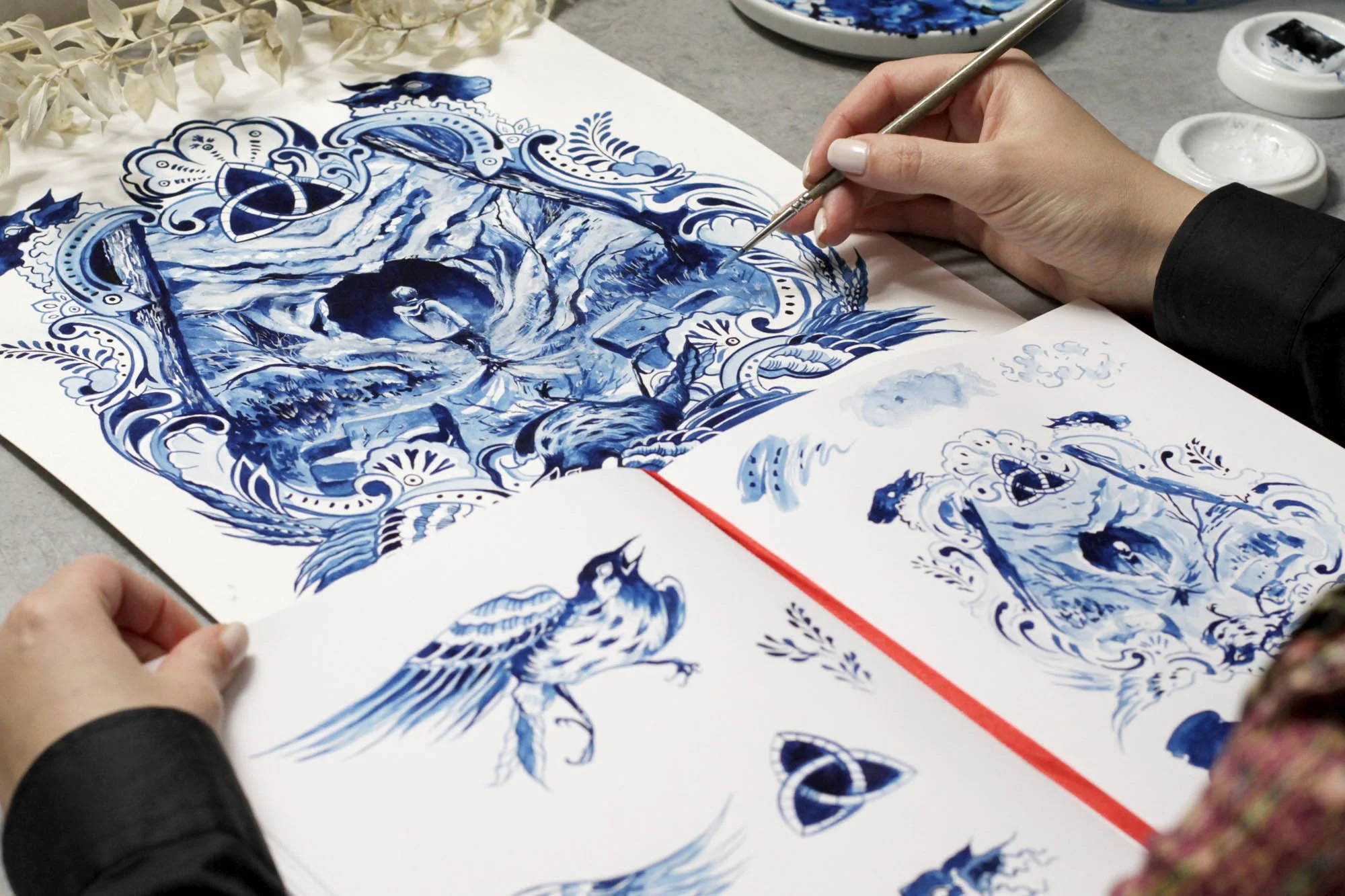 Studio view of Dark by Anna Sokolova showing the artwork in progress alongside preparatory sketches and Delft Blue design studies inspired by the Netflix series.
