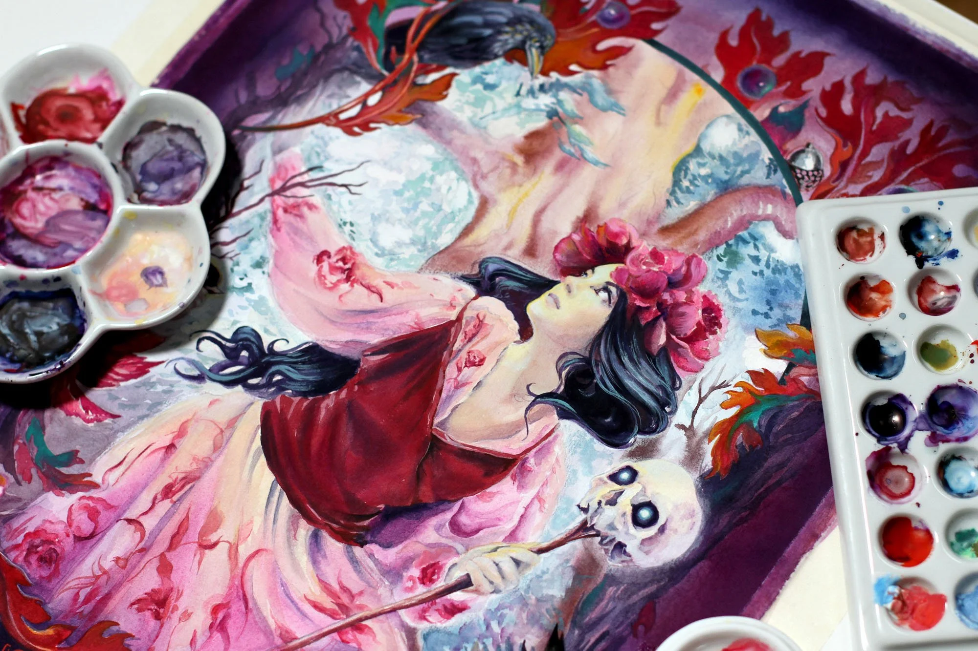 Process photo of Anna Sokolova’s Vasilisa the Beautiful artwork in progress, showing the painted fairy-tale heroine with a glowing skull lantern, surrounded by watercolor palettes and mixed-media materials.