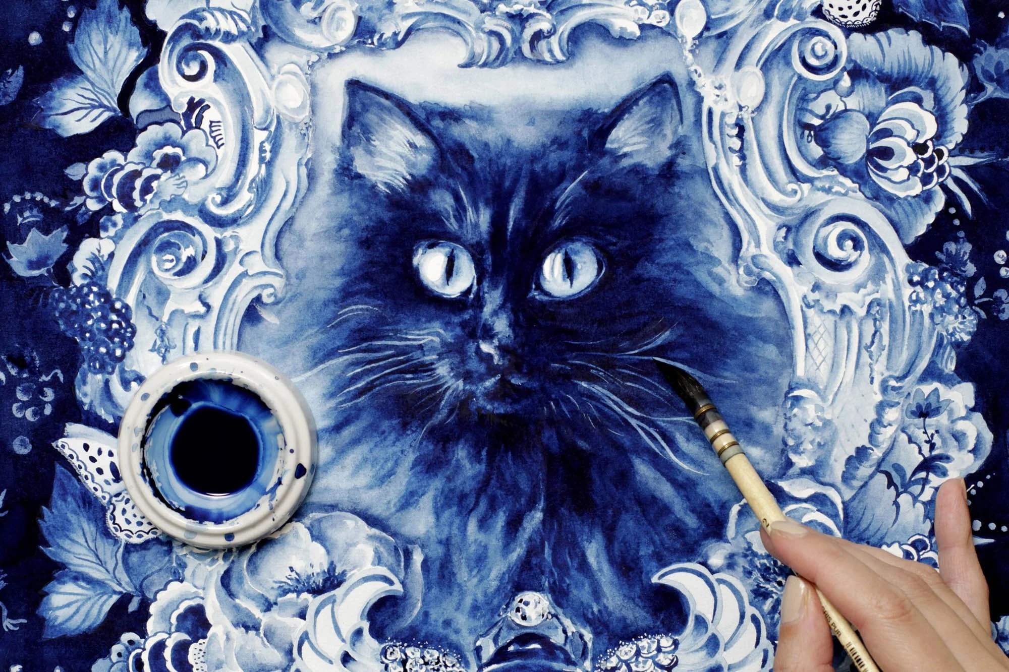 Artist painting the Behemoth artwork with a brush, developing the black cat portrait and decorative Delft Blue frame using watercolor, tempera, and gouache on cotton rag paper.