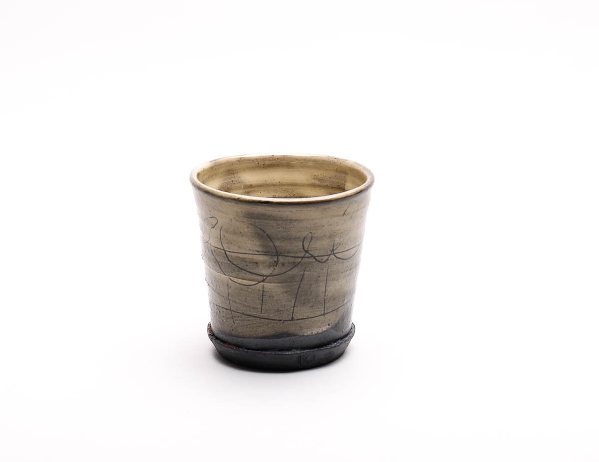 Earthenware beaker with dripped yellow glaze effect and dark features