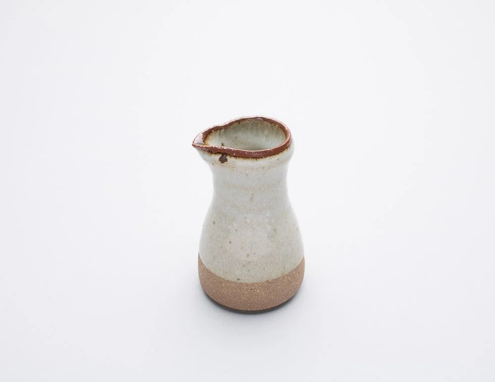 Standard Ware pourer in dolomite (creamy white) glaze, with raw clay on a small part of the bottom section . thin tenmuko glaze on rim of pourer.